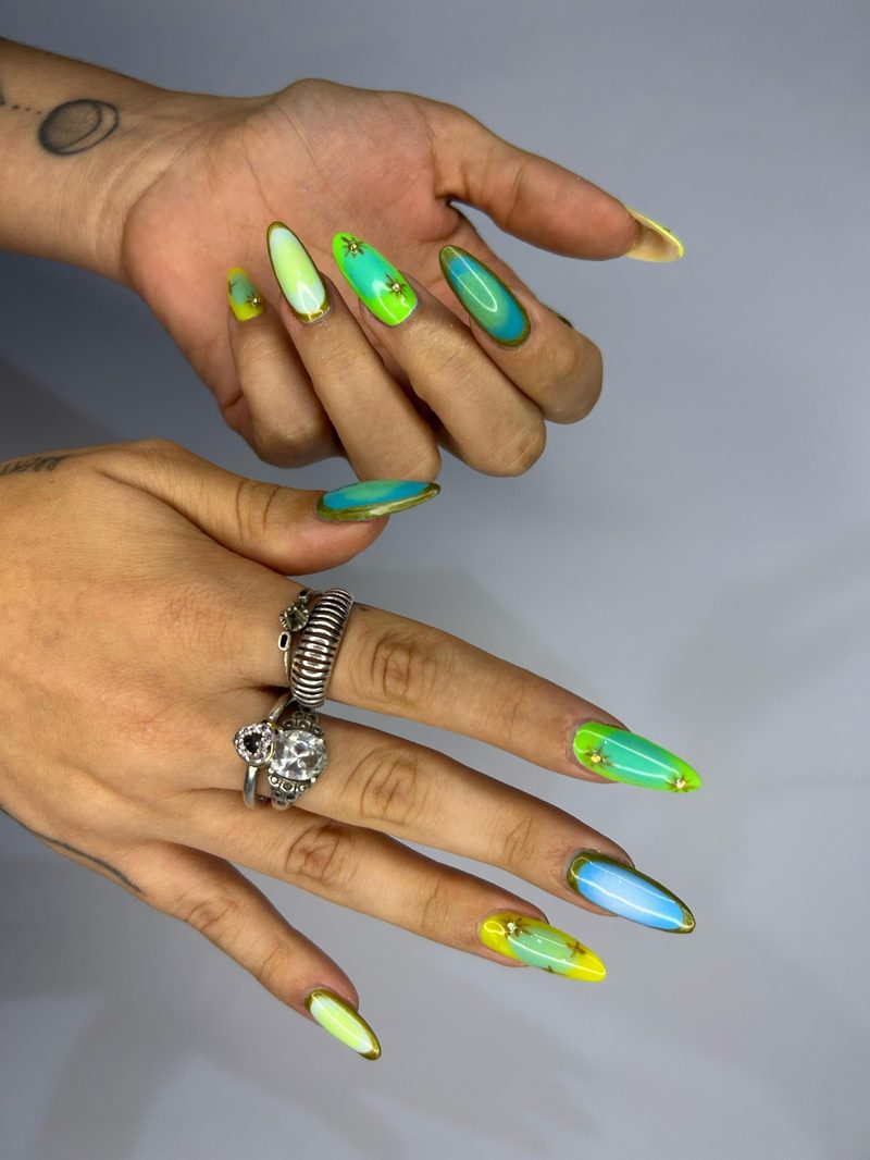 Nail art colorida em neon verde e amarelo sobre unhas alongadas